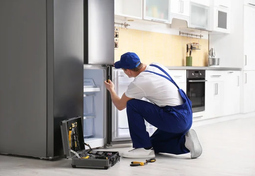 Technician servicing the lower compartment of a refrigerator